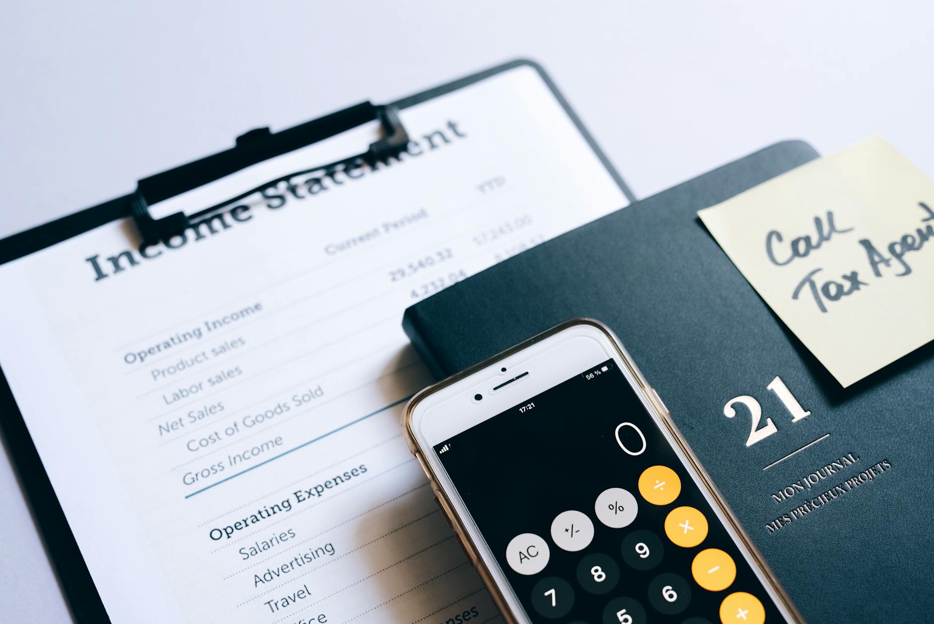 smartphone with opened calculator lying on a document with an income statement